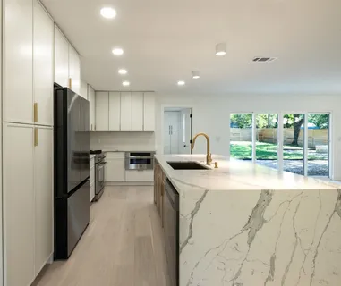 a kitchen with stainless steel appliances granite countertop a sink a refrigerator and a stove top oven