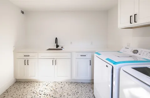 a kitchen with stainless steel appliances granite countertop a refrigerator a sink a stove and oven