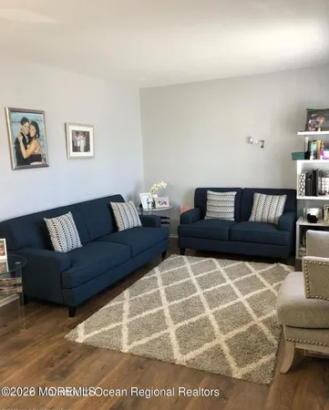 a living room with furniture and a black and white kitchen