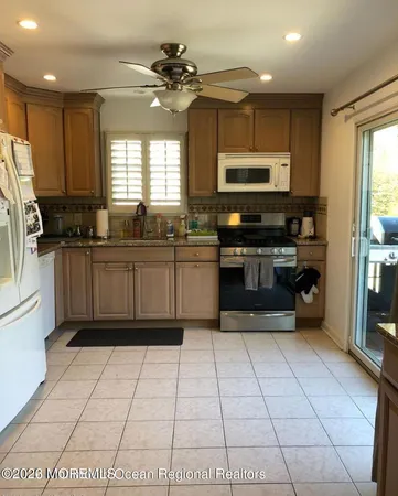 a kitchen with stainless steel appliances granite countertop a stove top oven a sink a counter top space cabinets and a window
