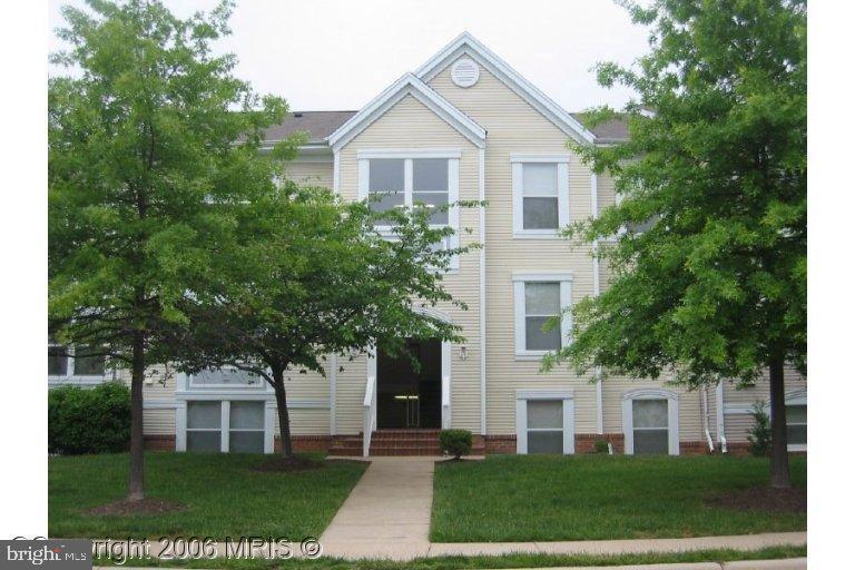 44116 Natalie Terrace, Unit 102 Ashburn, VA 20147 - Photo 1 of 24 a front view of a house with a yard and trees