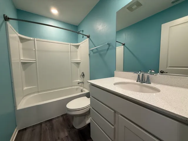 a bathroom with a sink a toilet and a large mirror