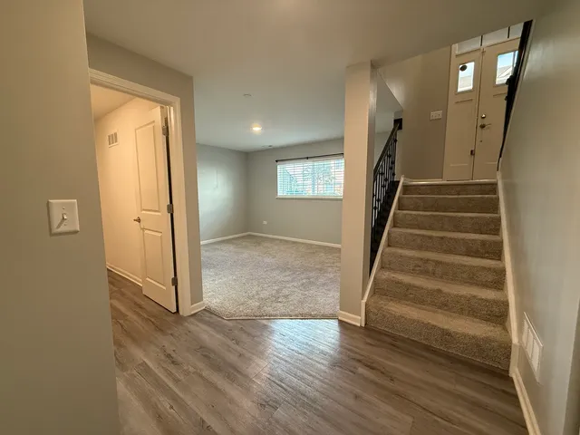 a view of a hallway with wooden floor and entryway