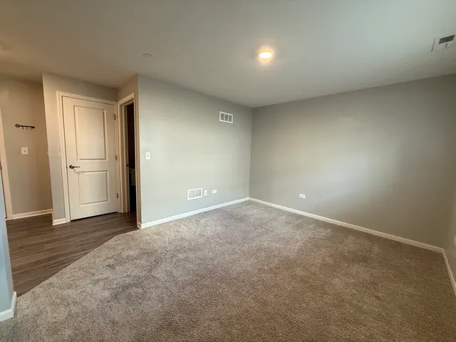 an empty room with wooden floor and cabinet