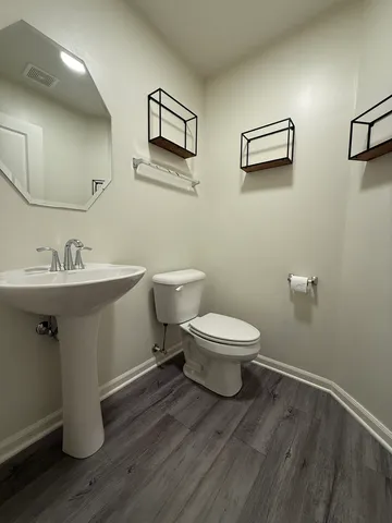 a bathroom with a toilet sink and mirror