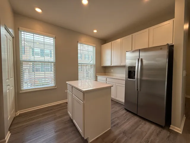 a kitchen with a refrigerator sink and cabinets