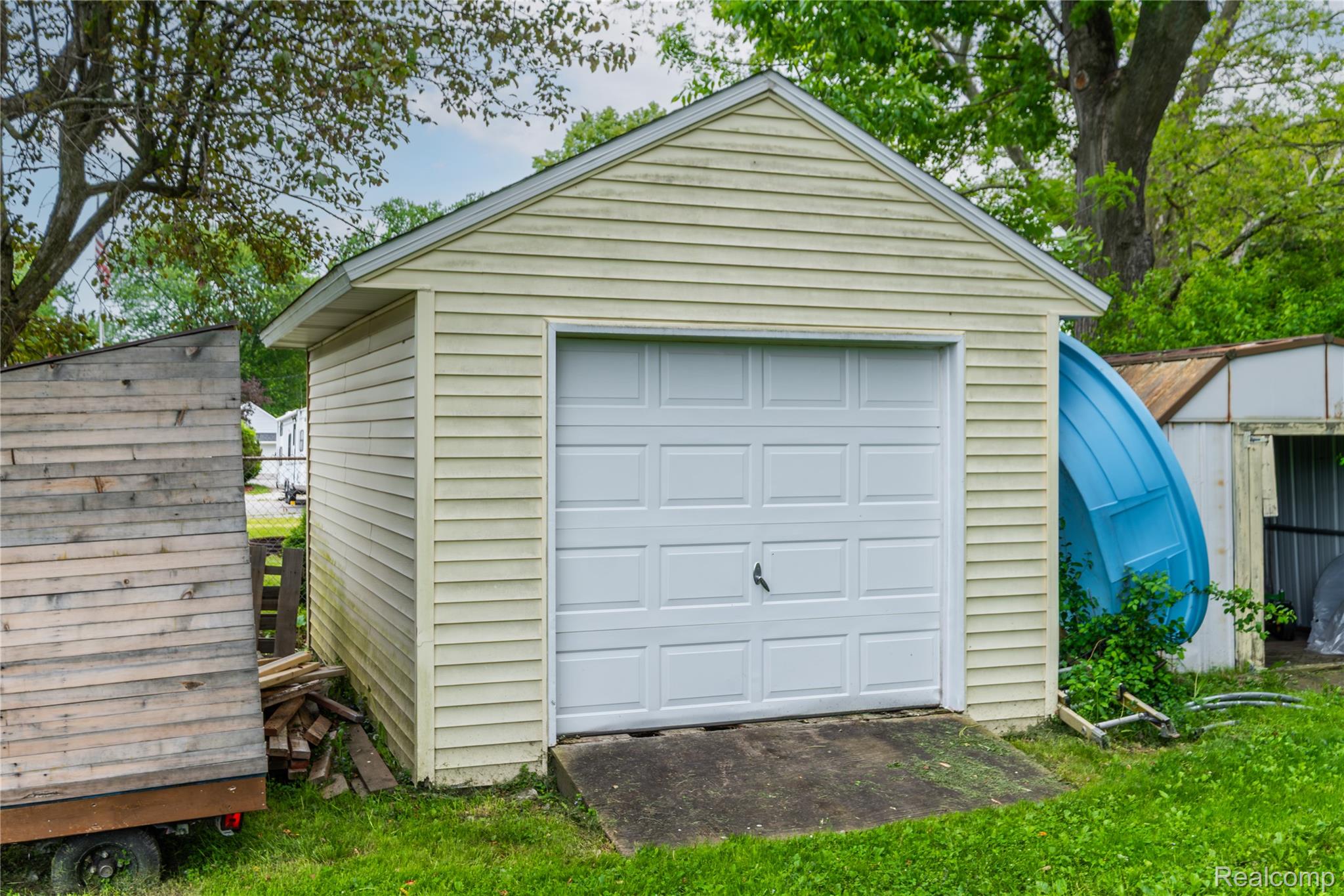 7800 Maple Street Birch Run, MI 48415 - Photo 26 of 29 Detached garage featuring light-colored siding, a white panel garage door, and a concrete approach