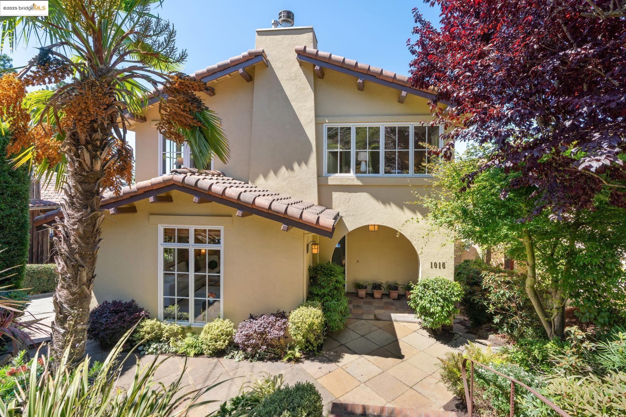 a front view of a house with a yard and potted plants