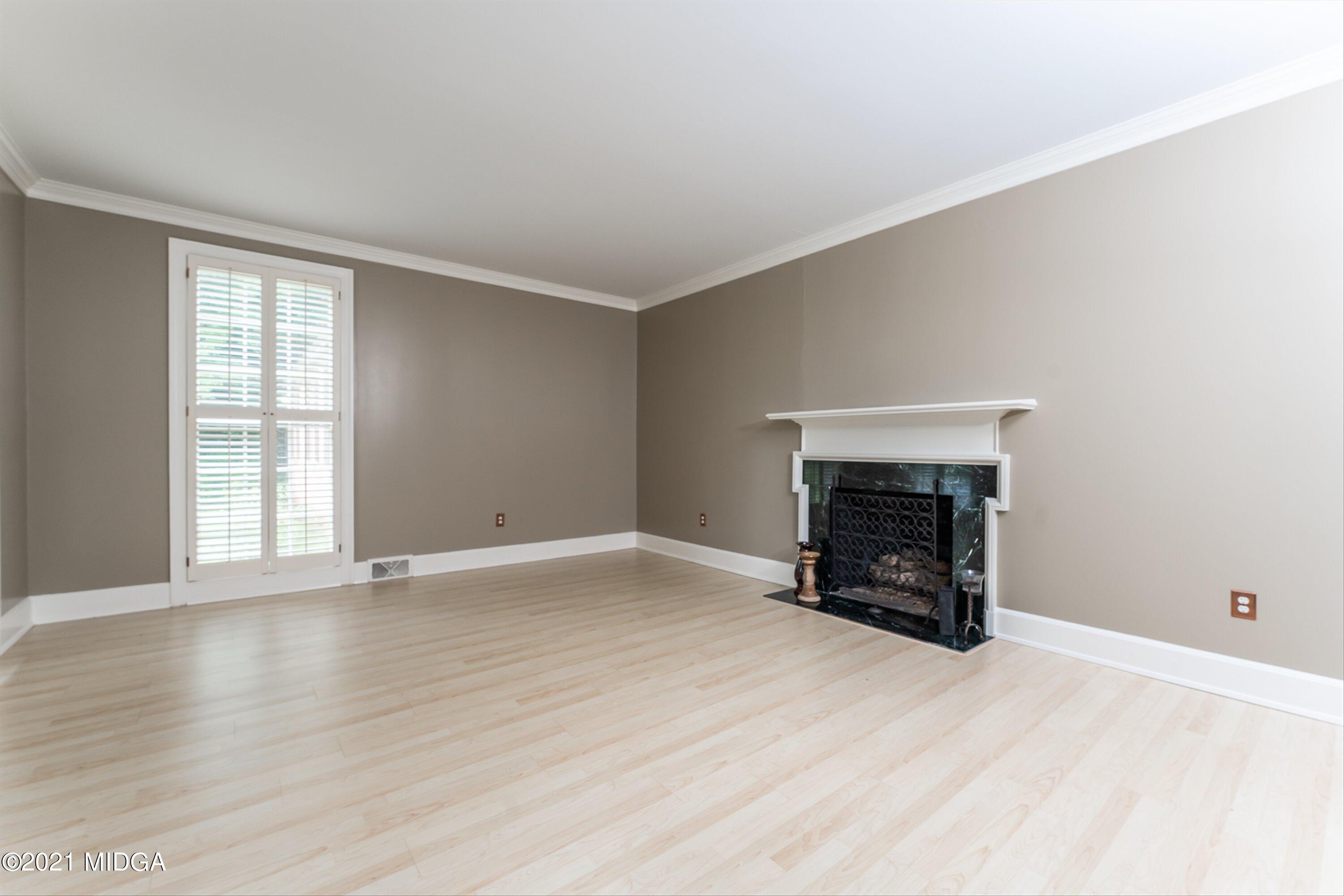 1845 Lincoln Road Macon, GA 31211 - Photo 11 of 31 an empty room with wooden floor fireplace and windows