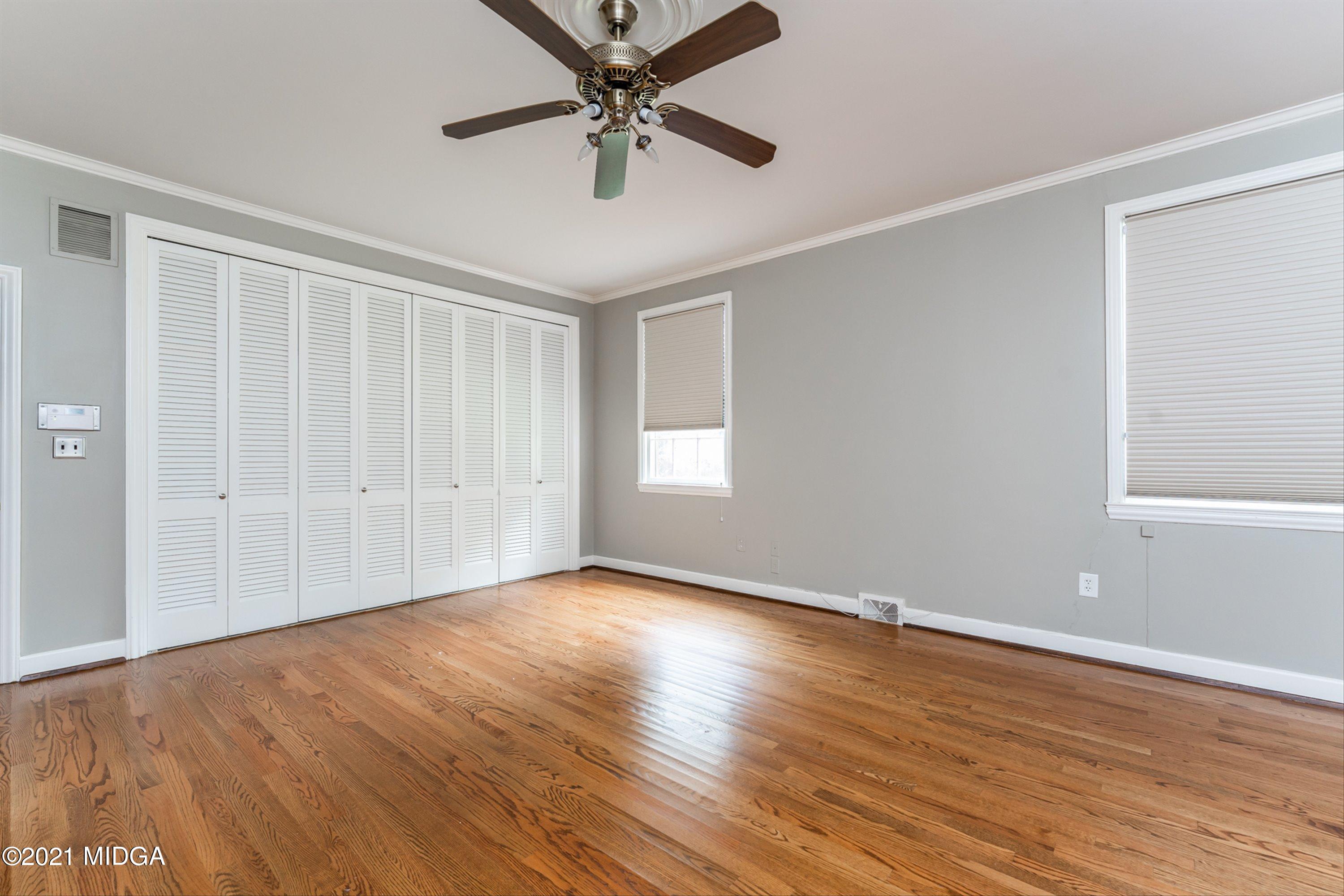 1845 Lincoln Road Macon, GA 31211 - Photo 24 of 31 an empty room with wooden floor chandelier fan and windows