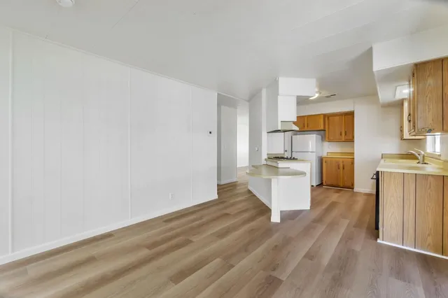 a view of a kitchen with a sink wooden cabinets and a window