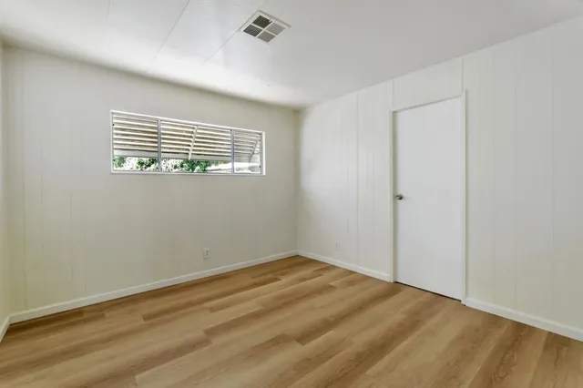 wooden floor in an empty room with a window