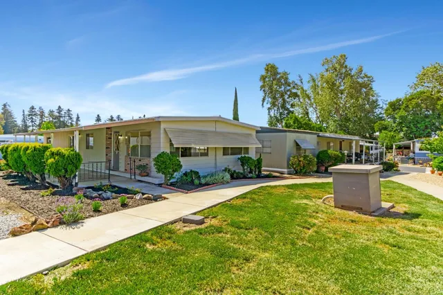 a view of a house with backyard and sitting area