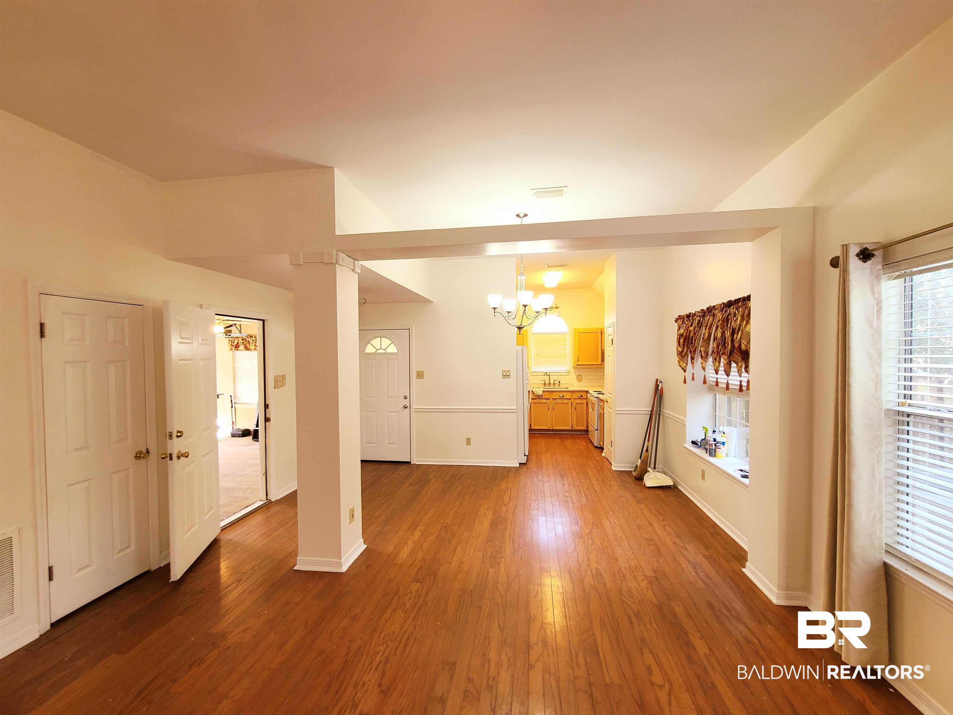 123 Melanie Loop Daphne, AL 36526 - Photo 5 of 17 Unfurnished living room featuring dark wood finished floors and hanging lights