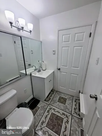 a bathroom with a sink a toilet a mirror and vanity