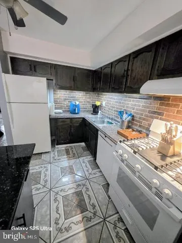 a kitchen with kitchen island granite countertop a sink and a stove