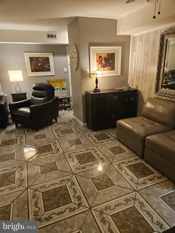a living room with a couch and a stove with wooden floor