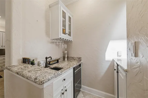 a kitchen with a refrigerator sink and cabinets