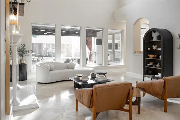 a living room with furniture a fireplace and potted plants