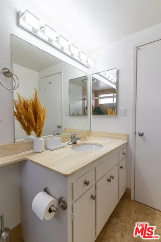 a bathroom with a sink vanity and mirror
