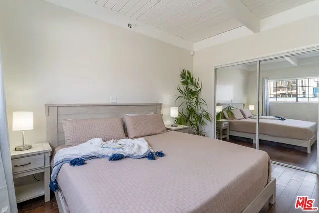 a bedroom with a large bed and potted plant
