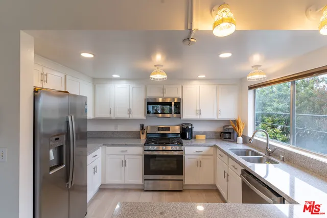 a kitchen with stainless steel appliances a refrigerator sink and cabinets