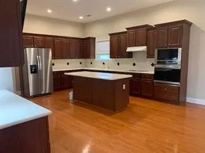 a kitchen with stainless steel appliances a sink a stove a refrigerator and cabinets