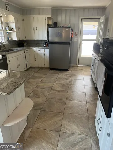 a kitchen with a sink a stove a refrigerator and cabinetry