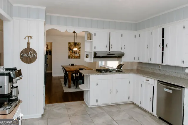 a kitchen with stainless steel appliances granite countertop a sink a stove a refrigerator and cabinets
