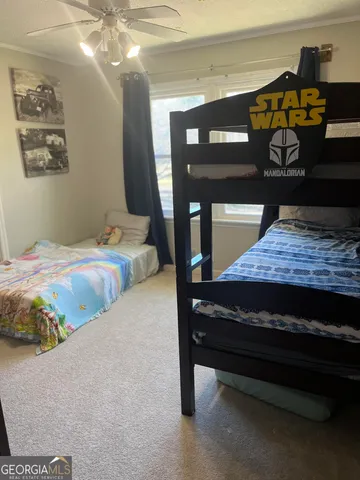 a bedroom with a bed and lamp on dresser