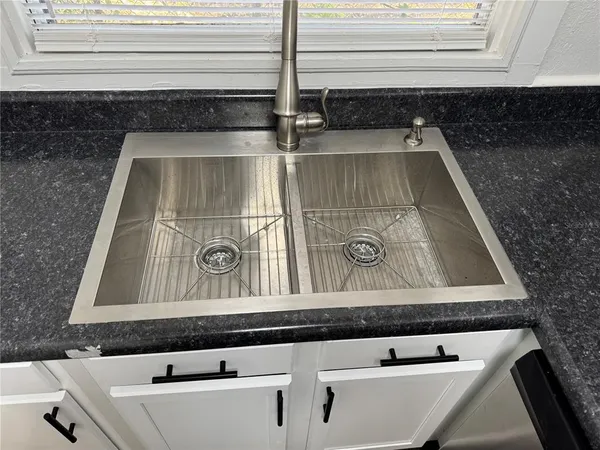 a view of a kitchen with a sink refrigerator and window