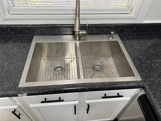 a view of a kitchen with a sink refrigerator and window