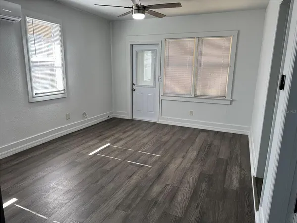 a view of an empty room with wooden floor