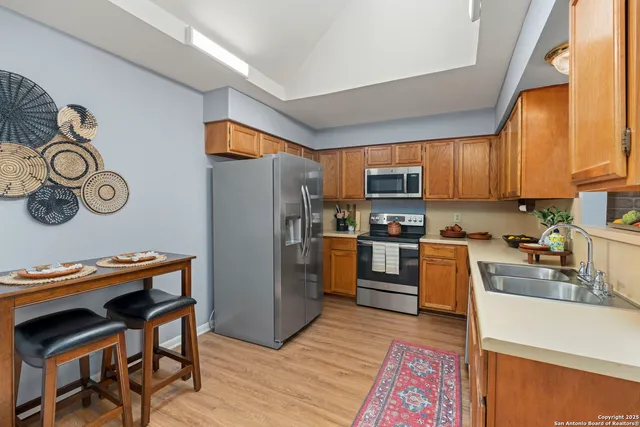 a kitchen with stainless steel appliances granite countertop a refrigerator a stove top oven a sink and dishwasher