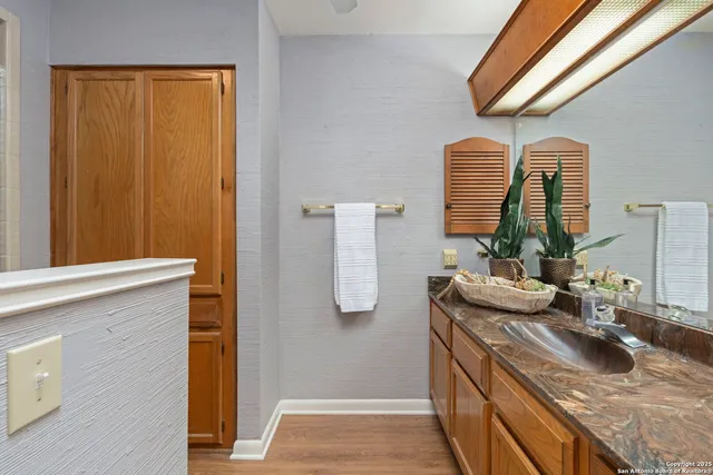a bathroom with a granite countertop sink and a mirror