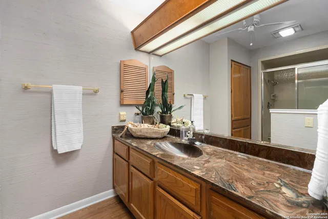 a bathroom with a granite countertop sink and a mirror