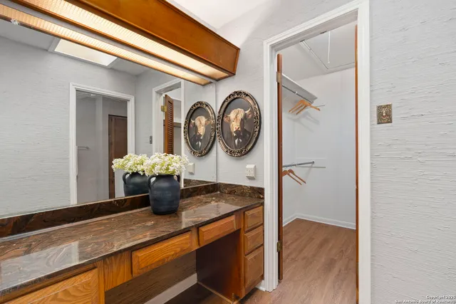 a kitchen with a sink and a stove with wooden floor
