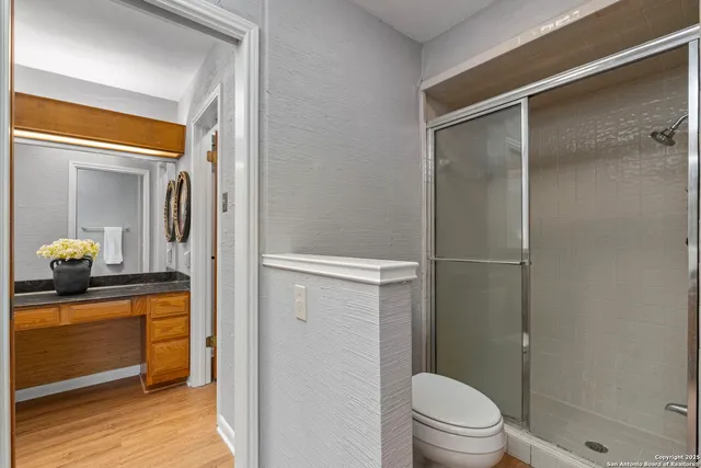 a bathroom with a granite countertop sink toilet and shower