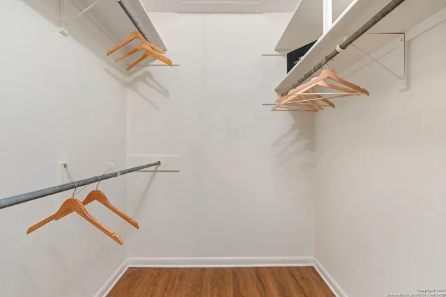 a view of walk in closet with empty racks
