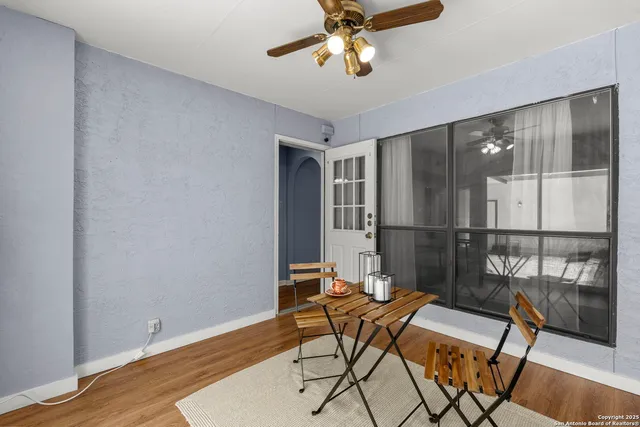 a view of a workspace with furniture and a ceiling fan