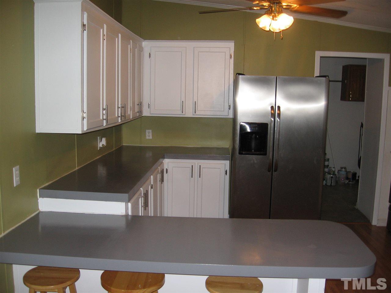 155 Charlie Fields Road Pittsboro, NC 27312 - Photo 12 of 25 partial view of kitchen from dining room. Contains brand new stainless steel appliances: refrig with icemaker, microwave, stove, & dishwasher.