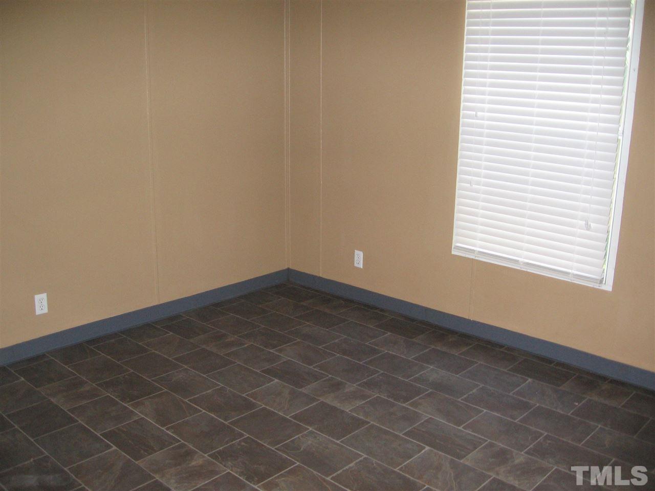 155 Charlie Fields Road Pittsboro, NC 27312 - Photo 18 of 25 2nd bedroom with walk in closet. Floors are a wonderful imitation tile. (pictures really do not to justice to the beautiful interior of this home.)