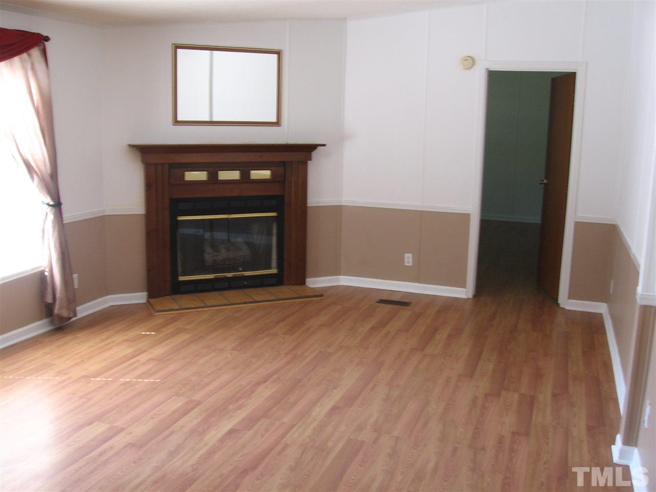 155 Charlie Fields Road Pittsboro, NC 27312 - Photo 9 of 25 23x13 living room with gas log fireplace. Door to right of f-place enters master bedroom. All window treatments stay if desired.