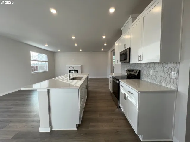 a kitchen with kitchen island sink stove and refrigerator