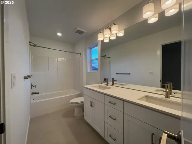 a bathroom with a granite countertop sink a toilet and a large mirror