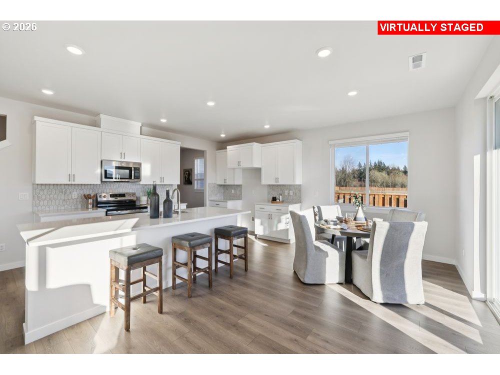 1001 Southwest 30th Street Battle Ground, WA 98604 - Photo 23 of 29 a living room with stainless steel appliances a dining table wooden floor windows and a kitchen view