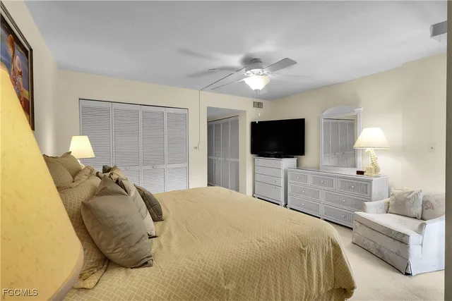 a bedroom with a bed flat screen tv and a chandelier