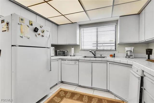 a white refrigerator freezer sitting inside of a kitchen