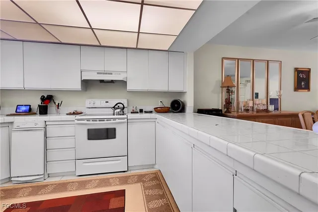 a kitchen with stainless steel appliances white cabinets and white appliances