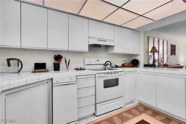 a kitchen with cabinets appliances a sink and a counter top